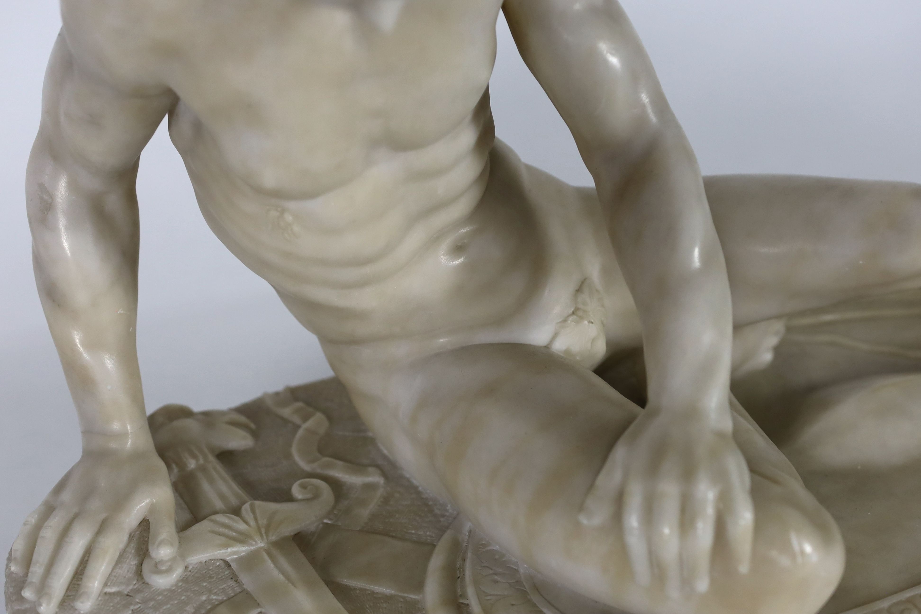 A late 19th century carved alabaster model of The Dying Gaul, width 65cm, height 43cm